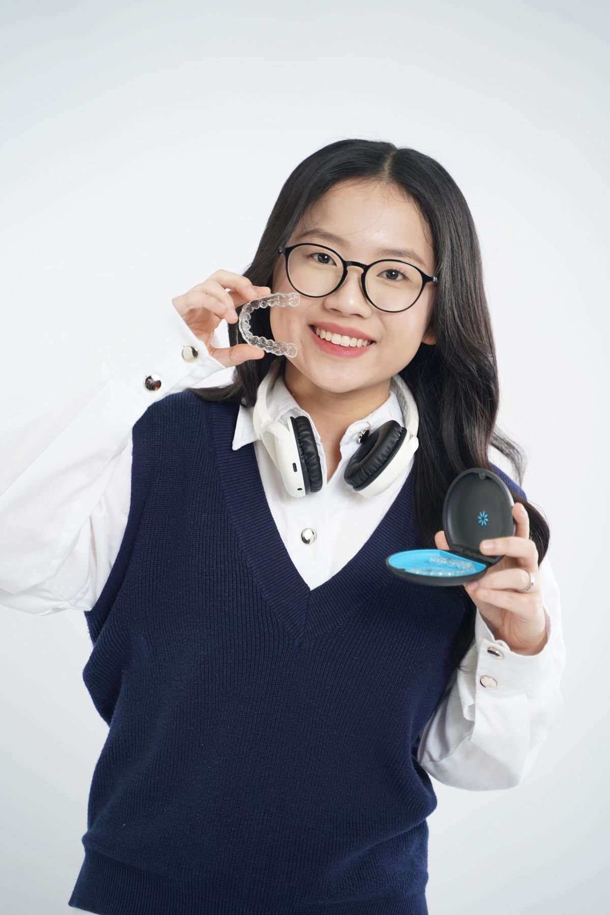 Woman holding a clear orthodontic aligner — illustrative stock photo
